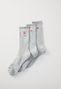 Graue Baumwollsocken mit gerippter Textur, verziert mit roten New Balance-Logos. Drei Paar zur Präsentation ausgerichtet.