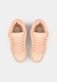 Peach leather sneakers with a smooth texture, rounded toe, flat laces, gold accents, and perforated detailing on the toe box.