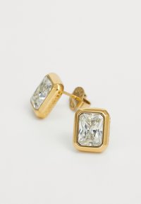 Boucles d'oreilles carrées en or avec une grande pierre rectangulaire claire et facettée, montée dans un chaton lisse en or.