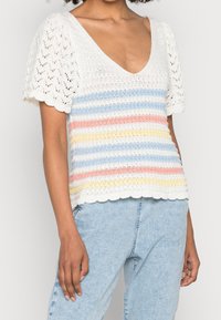 Strikbluse med V-udskæring, puffede ærmer og et stribet mønster i hvid, blød blå, pink, gul og bølget kant.