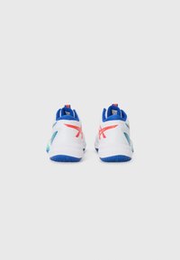 Baskets de sport blanches avec des accents bleus, présentant une tige lisse, des motifs latéraux colorés et une semelle bleue texturée. Détails rouges à l'arrière.