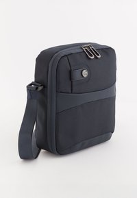 Navy nylon crossover taske med lynlås, rektangulær form, struktureret overflade, justerbar rem og frontaccentpanel.