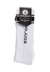 Witte crew-sokken met zwarte strepen en het "VOLCOM" logo, geribbelde textuur, maat 9-12. De verpakking bevat het merklogo en grafische designelementen.