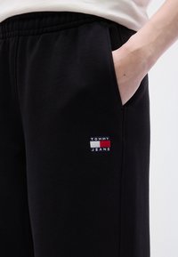 Μαύρο παντελόνι φόρμας με ελαστική μέση και πλαϊνές τσέπες. Διαθέτει ένα μικρό, κεντημένο λογότυπο σε κόκκινο, άσπρο και μπλε.