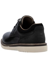 Scarpa di pelle nera con punta tonda, design con lacci, suola chiara a contrasto e texture liscia con dettagli di cucitura discreti.