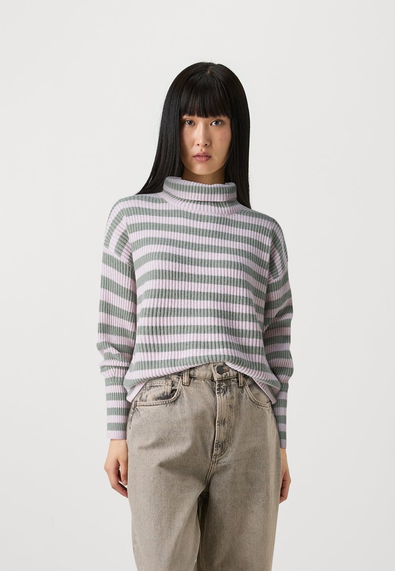 Striped sweater with a high neck, featuring alternating colors of grey, pink, and white. Ribbed texture and relaxed fit. Pairing with beige pants.