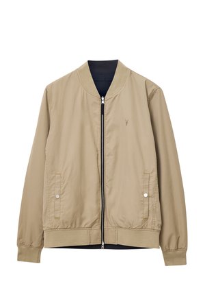 Beige bomberjacka med dragkedja framtill, ribbad krage och muddade ärmar. Två sidfickor med tryckknappar och subtil logotypdetalj.