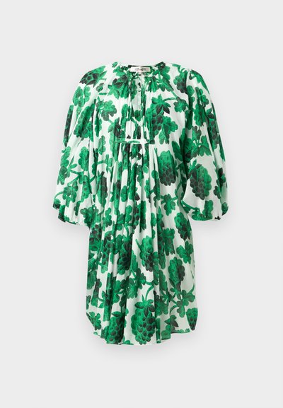 Vestido floral verde com mangas bufantes, apresentando um decote franzido e um tecido texturizado, com padrão de folhas verdes escuras e claras sobre um fundo branco.
