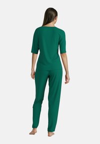 Groen loungewear set met een T-shirt met korte mouwen en bijpassende broek. Gemaakt van zacht, soepel materiaal met een relaxte pasvorm en geribbelde textuur.