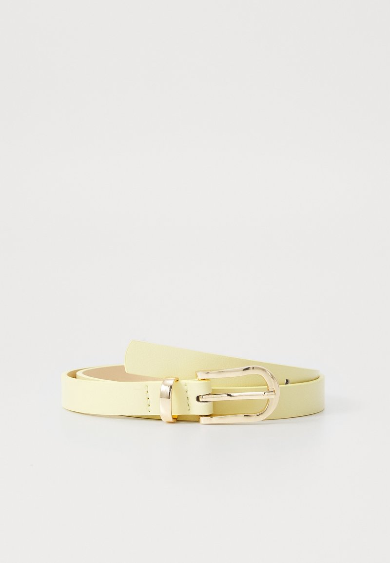 Ceinture en cuir jaune clair avec une boucle ronde dorée brillante, posée à plat sur un fond blanc.