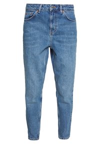 Vaaleansiniset farkut, joissa on kapenevat lahkeet, viisi taskua, metallinen napitus ja oranssit ompeleet. Taskujen lähellä kulutettu pinta.