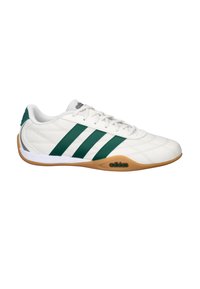 Zapatilla deportiva blanca con rayas de cuero verde, suela de goma, superficie texturizada y acentos grises en la lengüeta y el talón.