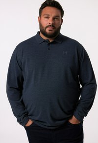 Námořnický polo tričko s dlouhým rukávem, rozšířeným límcem, tříbuttonovou légou a diskrétním detailem loga. Měkký materiál s uvolněným střihem.