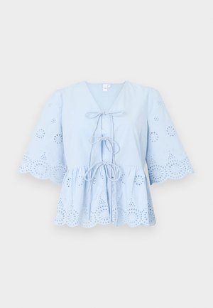 Modra bombažna bluza z V-izrezom, vezi spredaj in razširjenimi rokavi. Ima vezenine z izrezi in valovite robove ob koncu in rokavih.