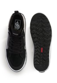 Zapatillas negras con un diseño de ante y malla, con una entresuela blanca, suela de goma negra con un patrón de textura y cordones.