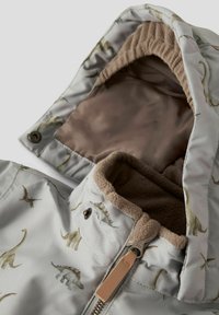 Chaqueta de color gris claro con cremallera y patrones de dinosaurios, que cuenta con una suave capucha y cuello forrados de felpa marrón. Incluye dos cierres de presión.