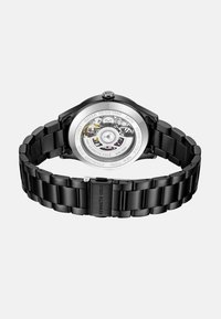 Orologio in acciaio inossidabile nero con fondello trasparente, che mostra i meccanismi interni e un bracciale metallico abbinato. Resistente all'acqua fino a 3 ATM.