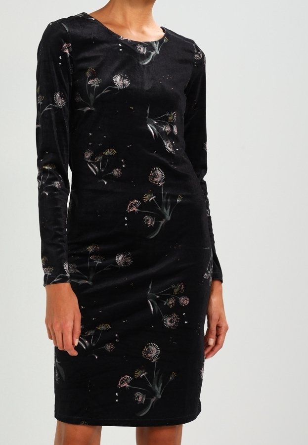 Robe noire en velours, longueur genoux, manches longues, ornée d'un subtil motif floral de pissenlit, portée par une personne debout.
