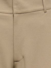 Beeži pükste lähivõte, kus on näha eesmine õmblus, vöökoht koos vööaasadega ja osaline tasku detail.