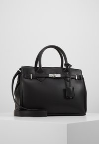Black leather handbag with dual handles, a detachable shoulder strap, silver hardware, and a hanging tag detail. Smooth texture and structured shape.