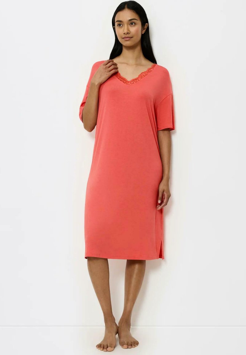 Koronkowa, luźno dopasowana nocna sukienka w kolorze koralowym, z krótkimi rękawami, dekoltem w kształcie litery V ozdobionym koronką oraz bocznymi rozcięciami dla wygody ruchów.