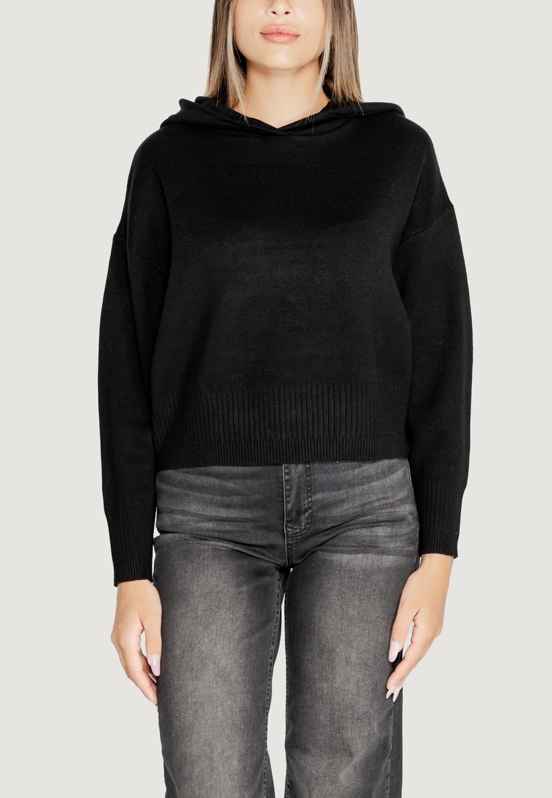 Felpa nera corta con orlo a costine e cappuccio, realizzata in tessuto morbido. Abbinata a jeans grigi scuri, con un taglio aderente e dettagli minimi.
