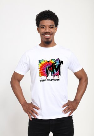 White cotton t-shirt featuring a multicolored tie-dye MTV logo design. Text includes "MUSIC TELEVISION" in black font below the logo.