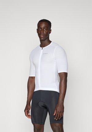 Maillot de cyclisme pour homme à manches courtes en tissu texturé blanc avec fermeture éclair à l'avant et logo. Associé à un short noir ajusté avec rembourrage.