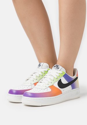 Nike Air Force 1 -tossut, joissa valkoinen nahkapäällinen ja liukuvärjättyjä korostuksia purppuran, oranssin, vihreän ja sinisen sävyissä sekä musta Swoosh-logo.