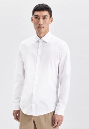 Witte button-up shirt met een kraag, lange mouwen, gladde stof en lichtblauwe knopen. Heeft een gebogen zoom en een getailleerde pasvorm.