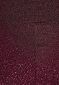 Tessuto testurizzato con motivo a zigzag in rosso scuro, caratterizzato da fili scintillanti che creano un effetto di luccichio sottile.