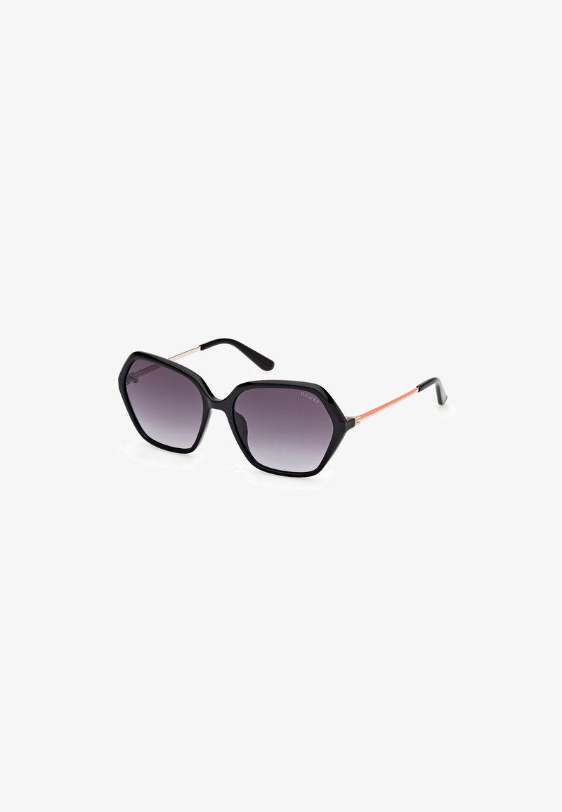 Sechseckige Sonnenbrille mit einem schwarzen Kunststoffrahmen und grauen Verlaufslinsen. Metallelemente an den Bügeln in Gold und Orange mit strukturiertem Finish.