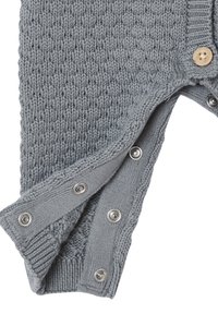 Graues gestricktes Kleidungsstück mit Druckknöpfen entlang des Randes und einem einzelnen Holzknopf im Bereich des Kragens, teilweise geöffnet gezeigt.