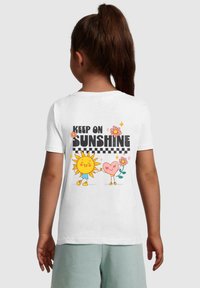Witte katoenen t-shirt met een kleurrafische afbeelding op de achterkant van een zon, een hart, bloemen en de tekst "KEEP ON SUNSHINE."
