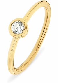 Anello d'oro con un singolo diamante rotondo e trasparente. La fascia è liscia, con un profilo snello e un design a leggera torsione.
