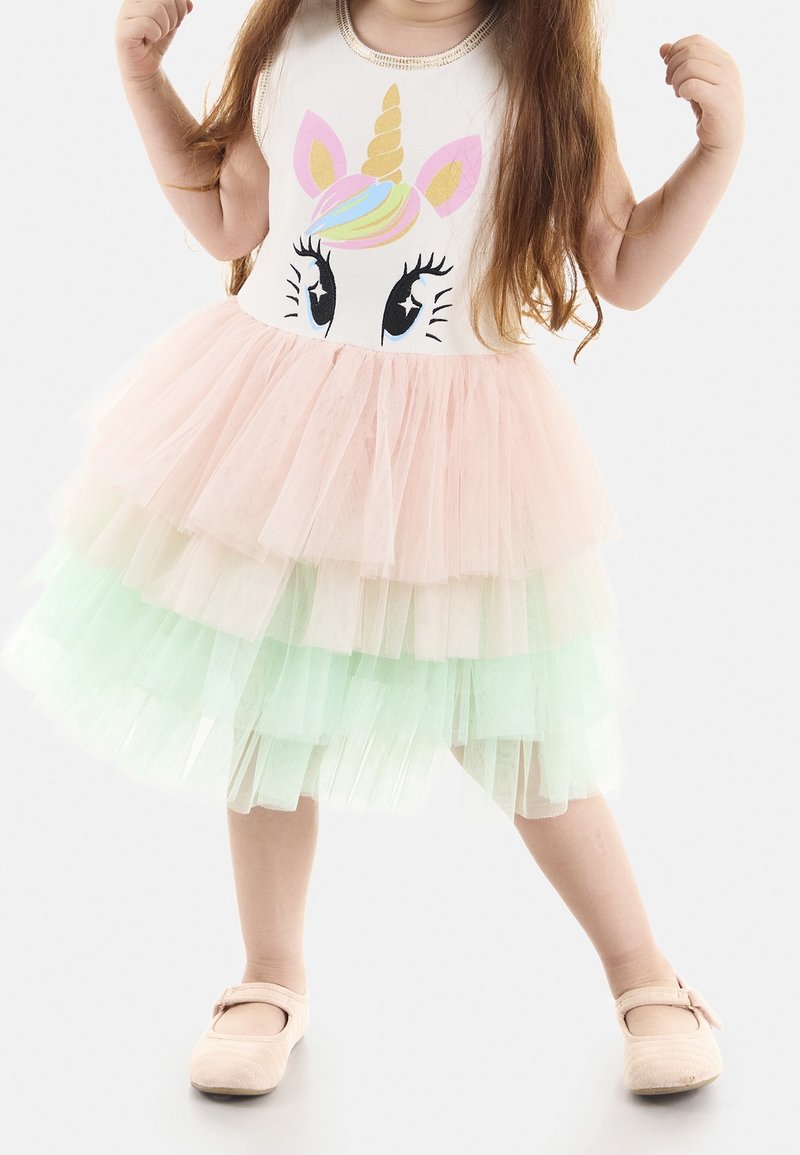 Einhorn-Themenkleid mit einem weißen Oberteil mit grafischem Design, mehrschichtigem Tüllrock in Pink und Mintgrün sowie weichen rosa Schuhen.