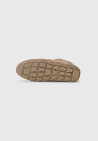 Semelle de basket en suede marron avec un motif en caoutchouc texturé. Présente des motifs rectangulaires pour une meilleure adhérence et une légère courbure au niveau des orteils.