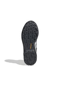 Semelle de chaussure en caoutchouc noir avec des crampons profonds, présentant un motif texturé et un logo "Continental" orange. Design plat et large pour une meilleure adhérence.