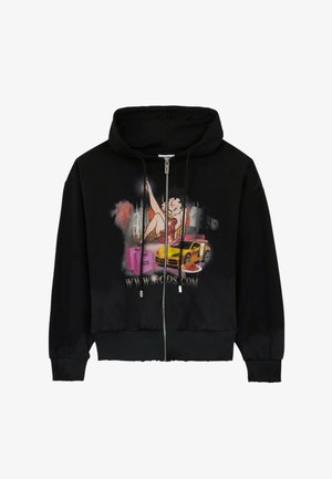 Felpa nera con cerniera con grafica di una donna in abito rosso, auto sportiva gialla, scatole rosa e un piatto di spaghetti con un URL del sito web sotto.