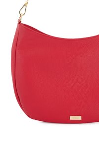 Sac bandoulière en cuir rouge avec une finition texturée, de forme incurvée et un accent logo doré. Il possède un attache de sangle à clip.
