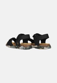 Black sandals with adjustable straps, featuring a textured, camouflaged sole and cork footbed for comfort.