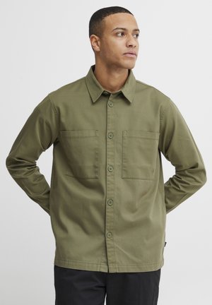 Olive green button-up shirt made of smooth fabric, featuring two chest pockets and a collared neckline, with long sleeves and straight hem.