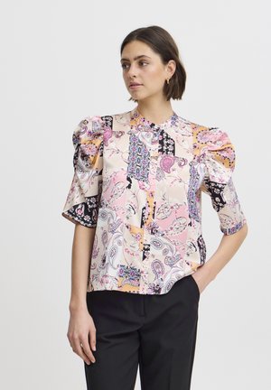 Bluză colorată cu un amestec de modele paisley și florale în nuanțe de roz, negru și crem, cu mâneci scurte bufante și închidere cu nasturi.