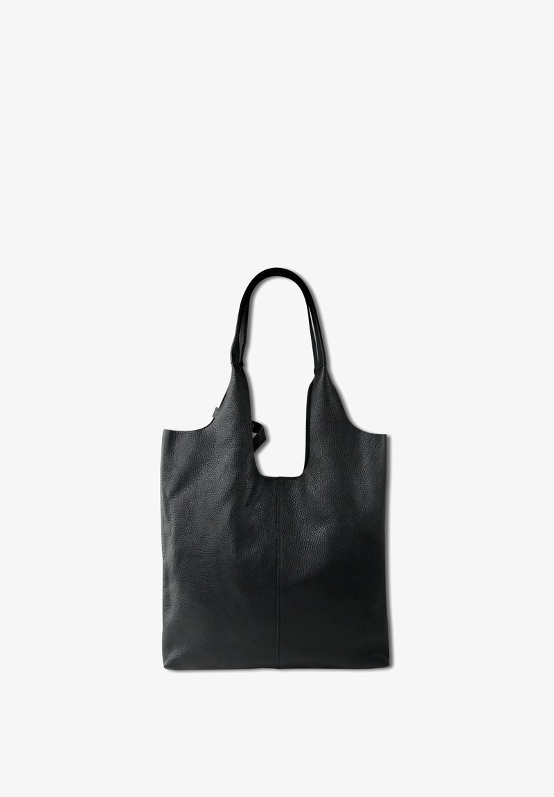 Black leather tote bag with textured surface, open top, and two shoulder straps. Features an elongated cut-out handle.