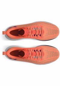 Baskets de sport orange vif avec une tige en maille, des perforations pour la respirabilité, des lacets plats et une semelle intermédiaire blanche. Présente un logo sur le côté.