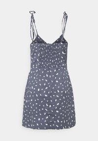 Granatowa sukienka z białymi nieregularnymi plamami, regulowane ramiączka, marszczony gorset i prosty krój, wykonana z lekkiego materiału.