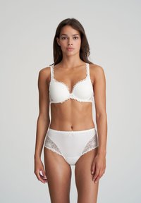 Set di reggiseno e slip bianco con dettagli in pizzo, tessuto morbido e un delicato fiocco sulla vita. Design classico con texture soffici.