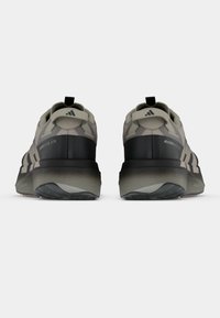 Graue und schwarze Sportschuhe mit verstärkter Ferse, strukturiertem Außenboden und drei schwarzen Streifen an den Seiten. Rückansicht, gepolstertes Design.