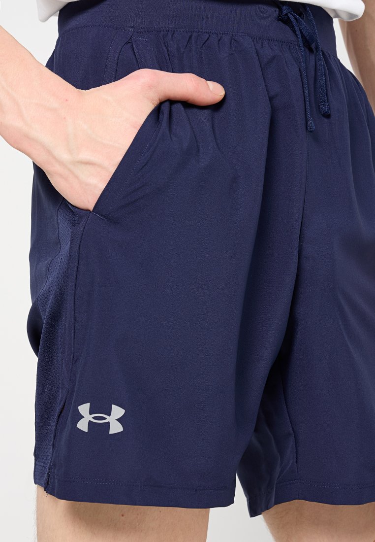 Pantalones cortos deportivos azul marino hechos de una tela ligera, con una cintura elástica, bolsillos laterales y un pequeño logo gris en el dobladillo.