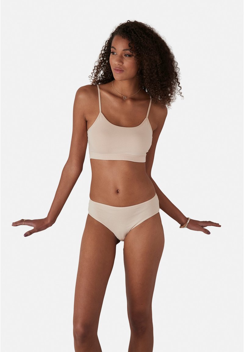 Beige jersey bralette met dunne bandjes en bijpassende hoge taille slipjes. Gladde textuur en aansluitend ontwerp. Eenvoudige, minimalistische stijl.